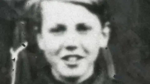 Leicester Mercury Archive University of Leicester A black and white picture of a young Sir David Attenborough. He is smiling at the camera.