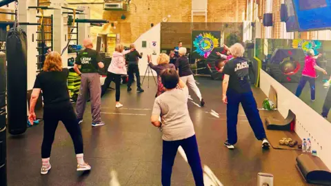 Paul Foley People taking part in an exercise class inside the gym.