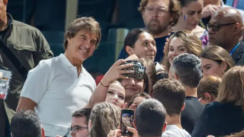 Getty Images Tom Cruise poses for a selfie with a fan in Paris