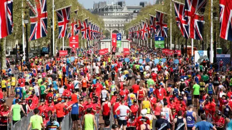 Runners cross the finish line at the London Marathon