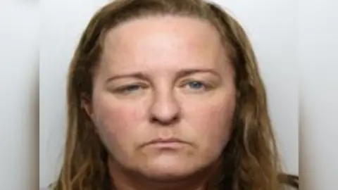 GMP A mugshot of an unsmiling Stacey Smith, a 46-year-old with brown hair and blue eyes. 