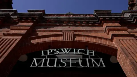 exterior and sign of Ipswich Museum showing red brick Victorian building and lettering