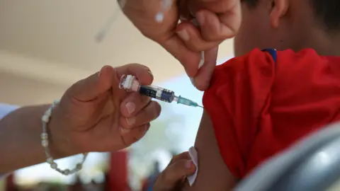 Reuters A young boy gets an injection in his arm.
