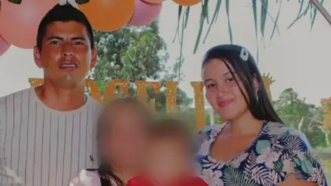 Courtesy of CSW A photo shows married couple  Isaíd Gómez and Maribel Silva with two children whose faces have been blurred. In the background balloons can be seen, suggesting they are attending a party. 