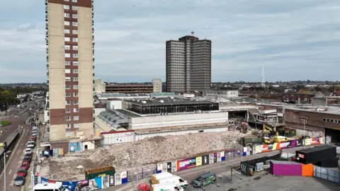 EFP Drone Footage/LDRS Aerial view of residential high-rise building Strand House towering over Bootle Strand shopping centre demolition site.