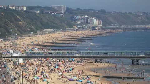 PA Media People enjoy the hot weather at Bournemouth beach in Dorset on 20 May