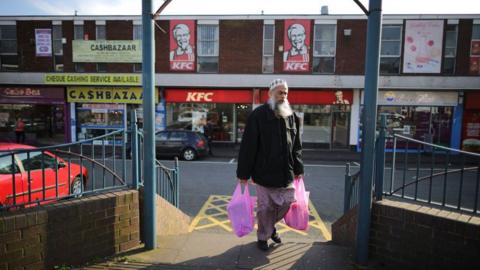 A man carrying his shopping on Soho Road