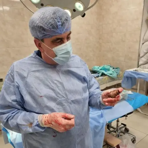 Facebook/Ukraine medical force command Surgeon Andrii Verba holds the grenade after the surgery