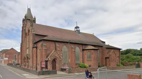 St Peter's Church. It is a red brick building with a tower.