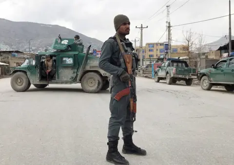 Reuters An Afghan policeman stands guard near the site of an attack in Kabul, Afghanistan March 25, 2020