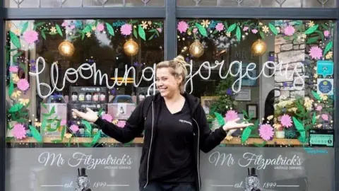 Ashleigh Morley Ashleigh Morley smiles outside Mr Fitzpatrick's while holding her hands out either side. 