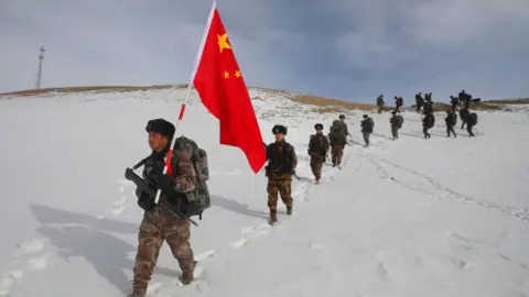 Getty Images Chinese troops march through the snow in Xinjiang