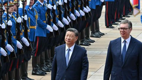 Serbian President Aleksandar Vucic walks with Chinese President Xi Jinping during a welcome ceremony in Belgrade