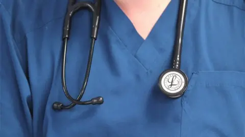 Close-up of doctor's blue tunic with a stethoscope