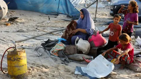 Palestinians go through their possessions after an overnight air strike in southern Gaza