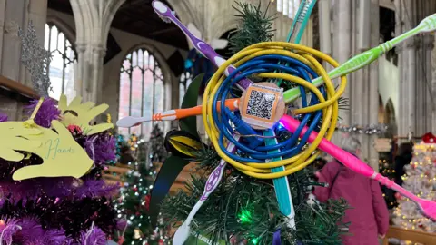 Christmas tree made out of toothbrushes, in a church