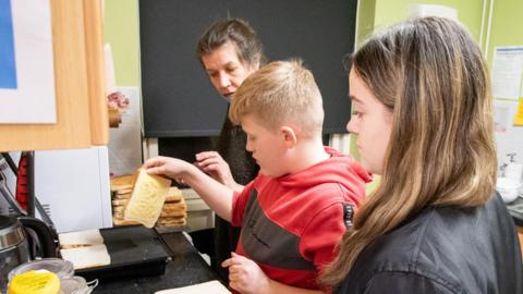 Pictures of children making toast with a charity 