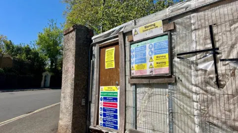 The entrance to the site was fenced off with wire mesh and building regulation notices visible.