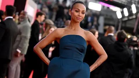 Getty Images US histrion  Zoe Saldaña poses connected  the reddish  carpet upon accomplishment  to be  the Gala screening of "Emilia Perez" astatine  the Royal Festival Hall, during the 2024 BFI London Film Festival successful  London, connected  October 11, 2024.