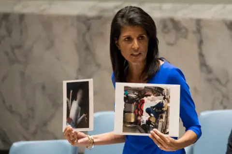 Getty Images Nikki Haley hold photos of dead Syrian children
