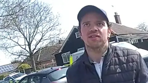 Police bodycam footage of Luke D'Wit outside the house Stephen and Carol Baxter.