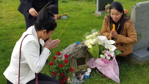 Thai Women's Network UK Two women kneeling at a gravestone
