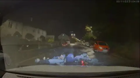 Court Handout/PA Wire A dashcam shot of two people lying in the road after a police car drove into them