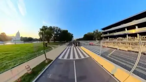 Fisheye view of a road with US Capitol on the left side.