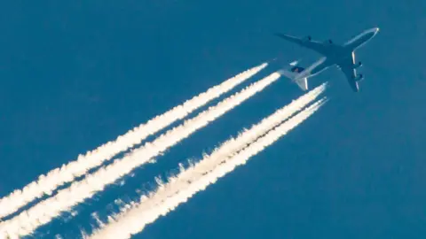 Getty Images A passenger aircraft and its engine exhaust contrails