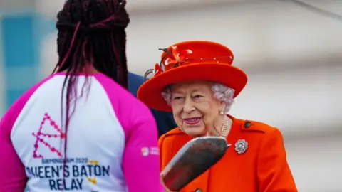 Birmingham 2022 Double Paralympic gold medallist Kadeena Cox being handed the baton by the Queen