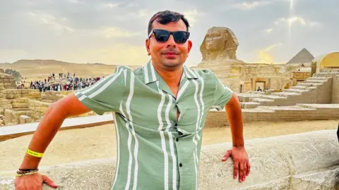 Ketan Shah on holiday in Egypt, wearing a green shirt and sunglasses, posing for a photo