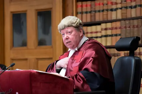 PA Media Judge Lord Carloway in a court room wearing. He is sitting at a lectern wearing his wig and gown.