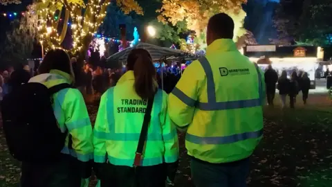 Derbyshire County Council Three people in high-vis trading standard coats at Matlock Bath Illuminations