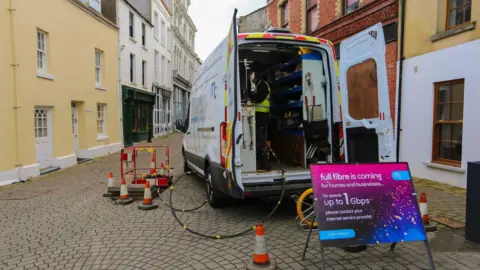 Michael Clarke The back of an open van with a sign saying fibre and works going on