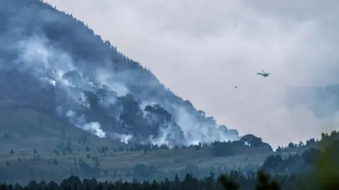 RSPB Scotland A helicopter dropping water on a wildfire in the Cairngorms.