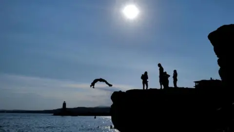 AFP People jump from rock into the Mediterranean Sea in the French Riviera city of Nice, 10 July 2022