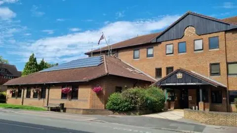 A photo of a large brown council building taken from the road outside