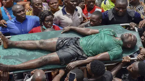 EPA Rescue workers carry a man rescued from the ruble at the scene of a building collapse in Ita Faji, Lagos, Nigeria, 13 March 2019