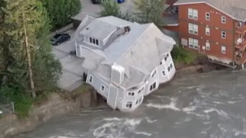 A building falling into a river