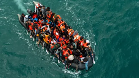 An aerial shot of a crowded boat crossing the English Channel.