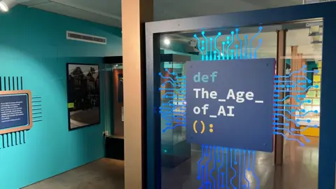 Sam Read/BBC The entrance of the Artificial Intelligence AI exhibition where the title of the exhibition is displayed to look like a blue computer chip.