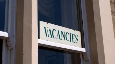 A vacancies sign in a bed and breakfast window.