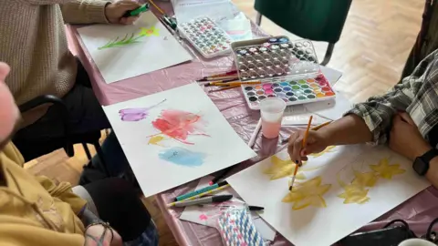 Emmy Porter Table of people doing watercolour painting during an art therapy class.