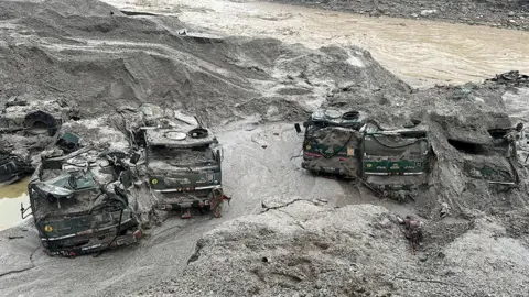 India Army via Reuters Trucks buried in mud are seen in an area affected by flood in Sikkim