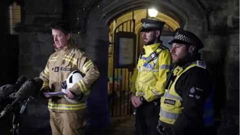 PA Media Andy Cole (left) from Dorset Wiltshire Fire and Rescue speaks to the media near the scene of a crash involving two trains