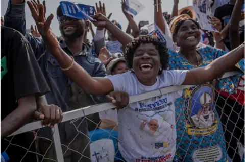 AFP Crowd cheering in DR Congo, wearing t-shirts with the Pope's face on it.