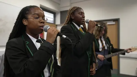 BBC Two girls singing and one playing guitar