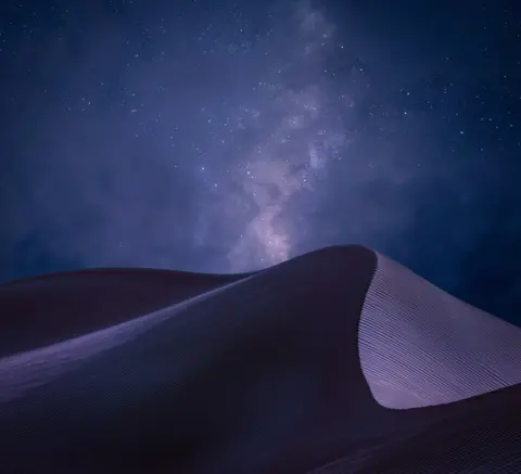 Peter Adam Hoszang A view of sand dunes beneath a night sky