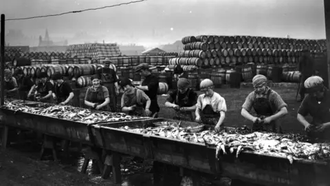 Getty Images Herring being gutted in Lowestoft in the 1920s