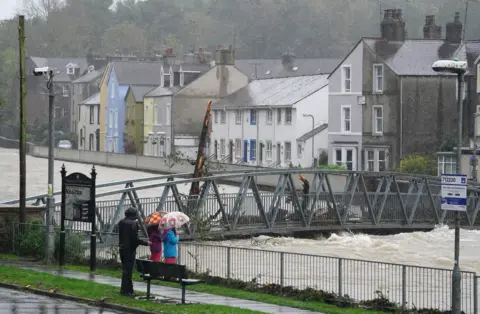 PA Media The river was level with the pedestrian bridge in Cockermouth